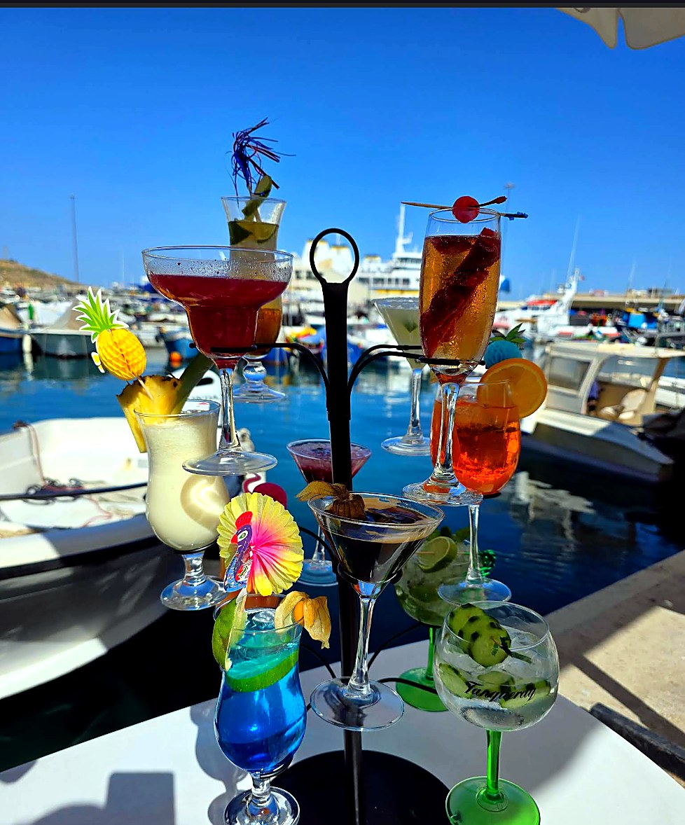 A cocktail stand with colourful drinks by the harbour.