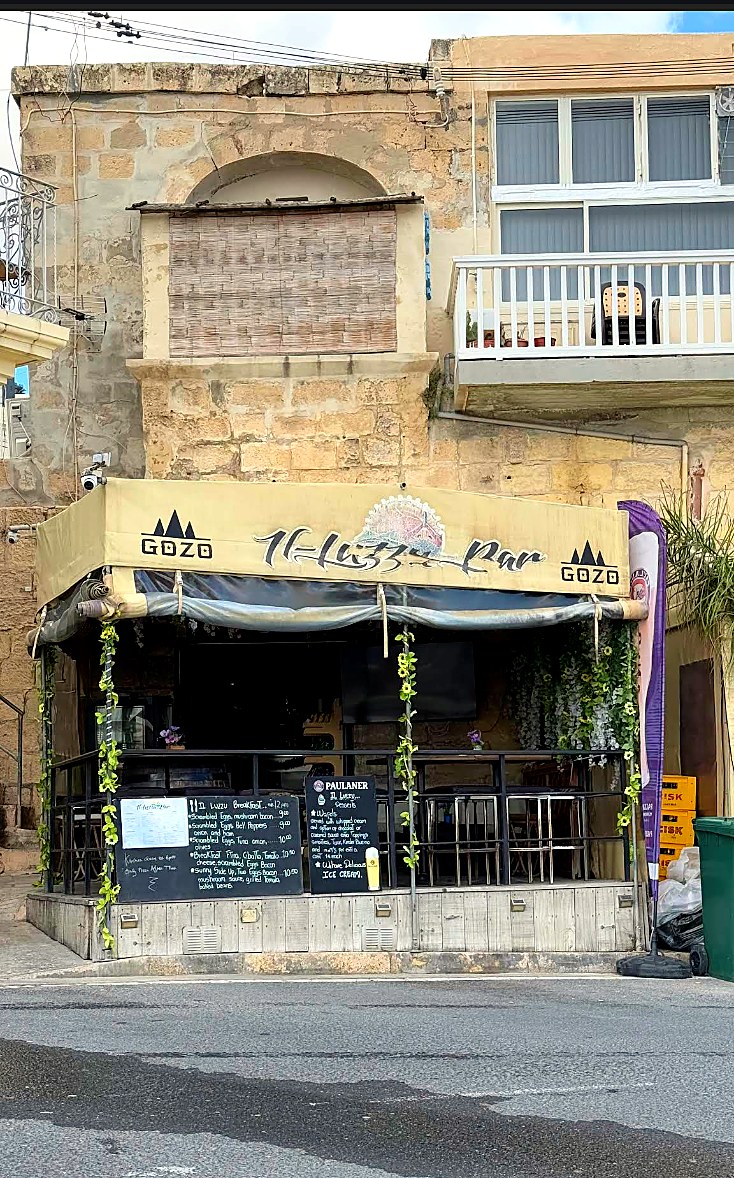 Il-Luzzu Bar frontage with awning and menu boards.