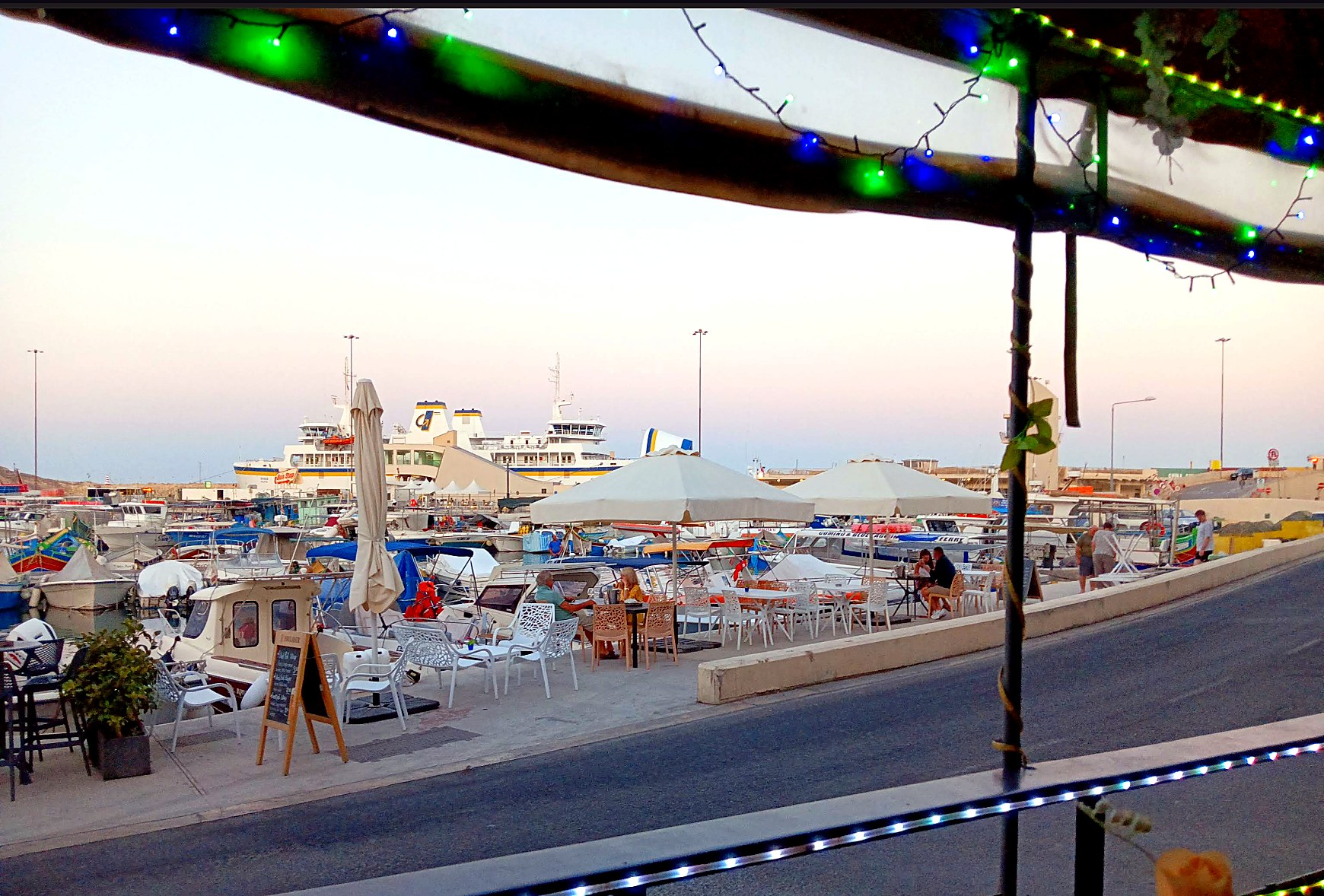 View from Il-Luzzu Bar terrace towards Mġarr harbour at sunset.
